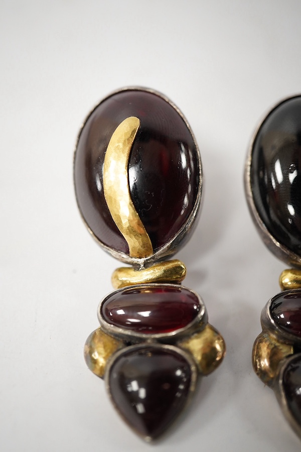 A pair of modern yellow and white metal mounted three stone oval cabochon garnet set drop earrings, by Elaine Coyne, signed, 51mm, gross weight 28.2 grams. Condition - fair